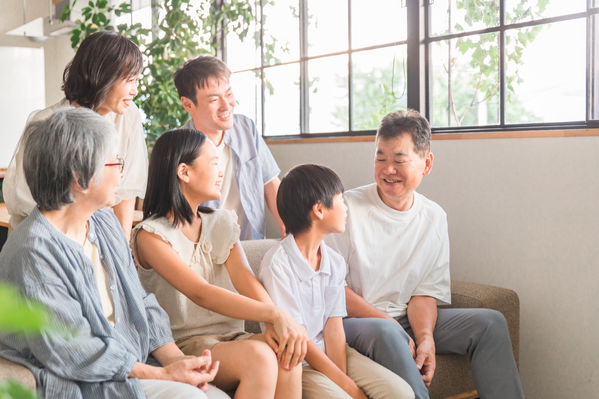 家のソファで家族団欒する三世代家族